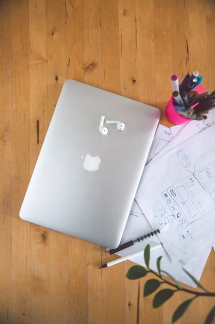 A sleek office desk setup featuring Apple devices: iMac, MacBook, and iPad.
