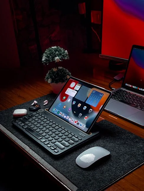 Dual monitors on a desk, showcasing web design in a modern office setting.